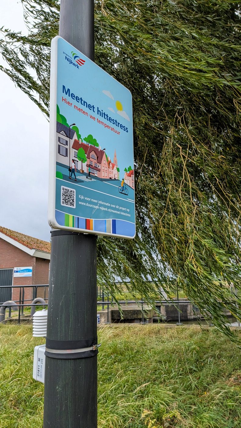 Informatiebord met QR-code bij een hittestresssensor in Nijkerk